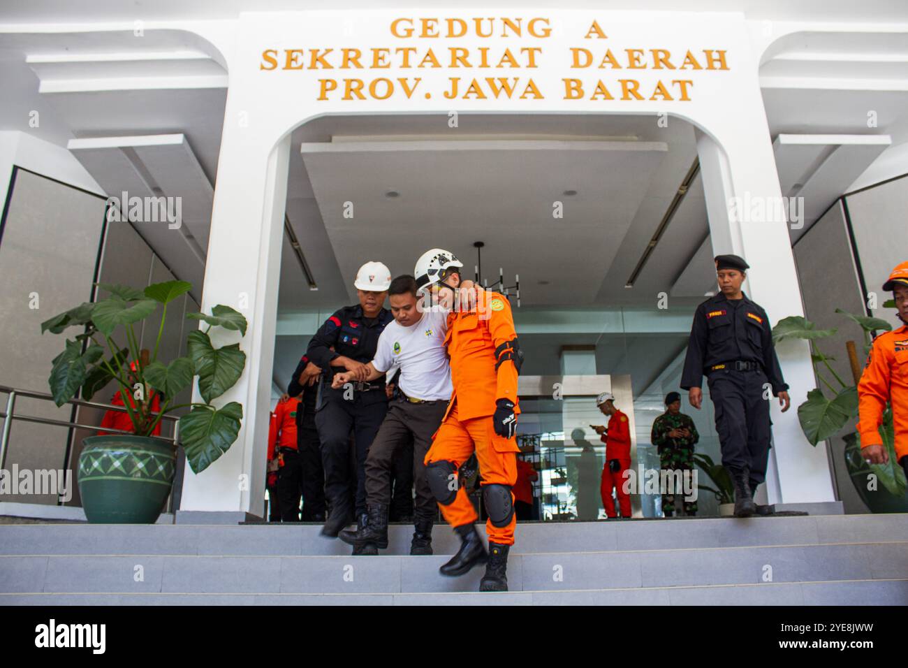 Gli agenti congiunti aiutano un uomo a giocare come vittima ferita durante un'esercitazione terremoto per ridurre il rischio di catastrofi. La Regional Disaster Management Agency (BPBD) della Provincia di Giava Occidentale e gli ufficiali congiunti hanno organizzato un'esercitazione di evacuazione del terremoto come parte di un programma di educazione alla sensibilizzazione in caso di disastri. La faglia di Lembang, con un terremoto di magnitudo potenziale 6.6-7, minaccia da 1,9 a 2,7 milioni di persone a Bandung e nelle aree circostanti ed è soggetta ad alti livelli di agitazione. L'Indonesia si trova sulla cintura di fuoco del Pacifico, che rappresenta il 80% dell'attività sismica mondiale. (Foto di A. Foto Stock