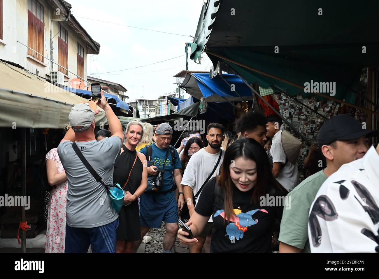 "Mercato ferroviario Thailandia" turisti e popolazioni locali emozionanti shopping e passeggiate lungo i binari ferroviari del mercato ferroviario di Mae Klong Thailandia Bangkok Foto Stock