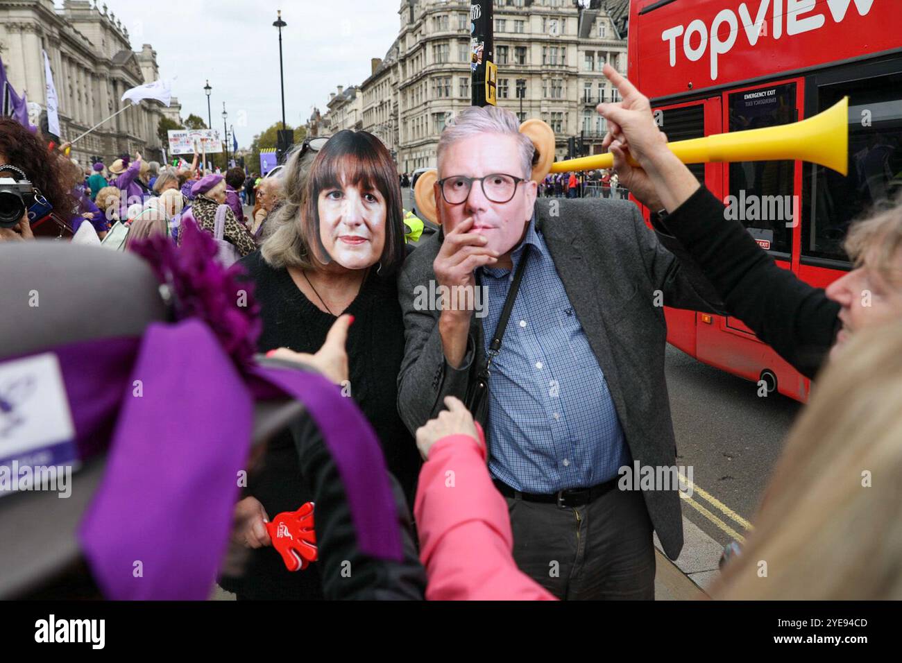 Londra, Regno Unito, 30 ottobre 2024.Un uomo e una donna indossano le maschere Rachel Reeves e Kier Starmer ad una manifestazione WASPI Woman in Parliament Square il giorno del budget. Mentre la cancelliera laburista Rachel Reeves consegna il primo bilancio laburista per 14 anni, le proteste si tengono al di fuori delle camere del Parlamento. La prima cancelliera donna del Regno Unito ha ripetutamente avvertito degli elevati aumenti fiscali e dei tagli alla spesa fino a 40 miliardi di sterline. Le donne manifestanti di WASPI occupano la piazza del Parlamento mentre il bilancio viene consegnato ai parlamentari e al paese. Crediti: James Willoughby/ALAMY Live News Foto Stock