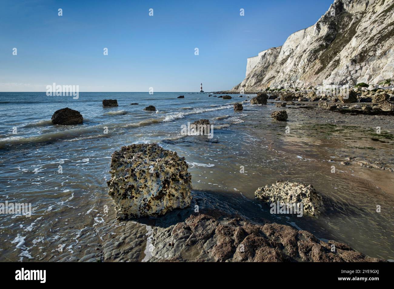 Chalk Boulders sotto Beachy Head e Beachy Head Lighthouse, vicino a Eastbourne, South Downs National Park, East Sussex, Inghilterra, Regno Unito Foto Stock