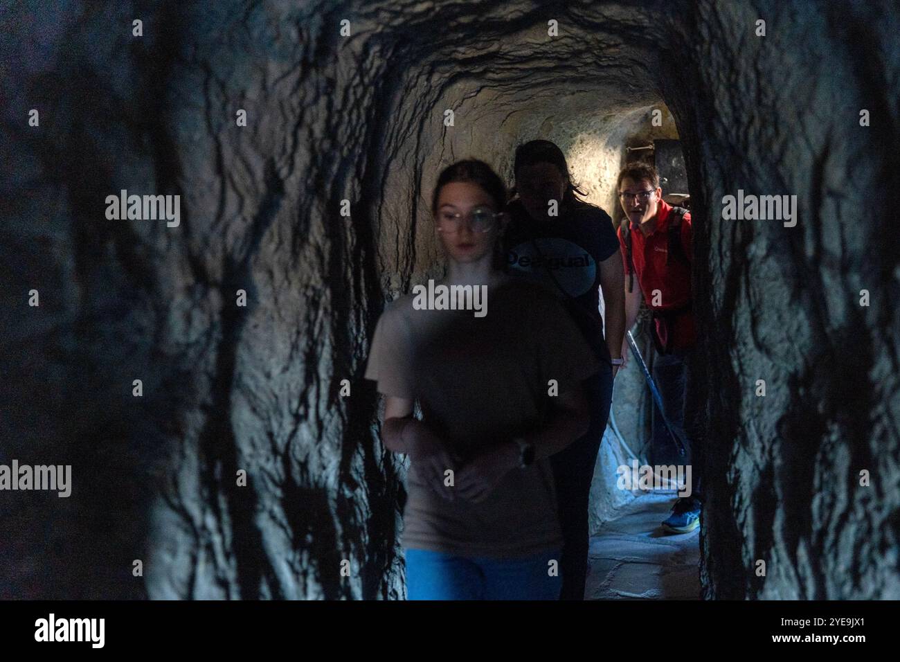 Volti sorpresi: I visitatori in uno stretto passaggio di un monastero greco Foto Stock