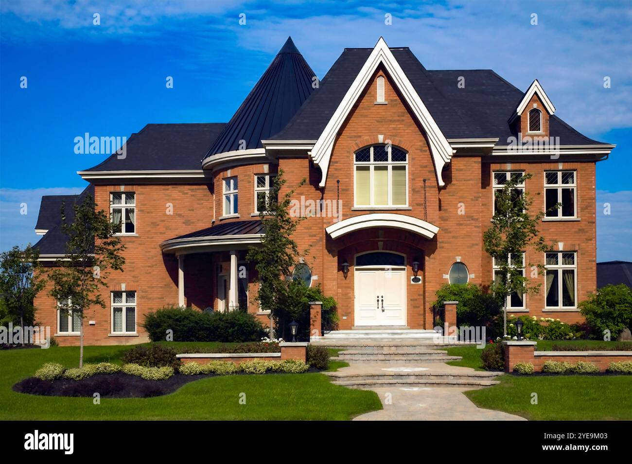 Casa residenziale con passerella, scalini e giardino paesaggistico sotto un cielo blu e nuvole; Quebec, Canada Foto Stock