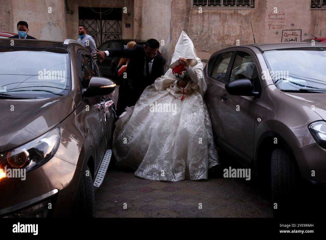 Gaza, Palestina. 9 settembre 2020. Una coppia palestinese si sposa a Gaza City in una piccola cerimonia nuziale limitata ai membri della famiglia più stretti, con distanziamento sociale e maschere facciali parte dell'evento. Dal 24 agosto, quando i casi di Covid-19 sono stati individuati per la prima volta tra la popolazione della Striscia di Gaza, si è registrato un drastico aumento delle infezioni da virus nel territorio palestinese. Le autorità hanno lottato con l'aumento del numero di casi a Gaza, una delle aree più densamente popolate del mondo e con un'infrastruttura sanitaria sovraccarica e scarsamente alimentata Foto Stock