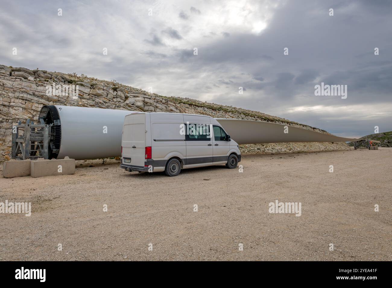 Una pala del rotore di una turbina eolica a terra lungo il lato di un furgone, che mostra le dimensioni e le dimensioni effettive del prodotto. Foto Stock