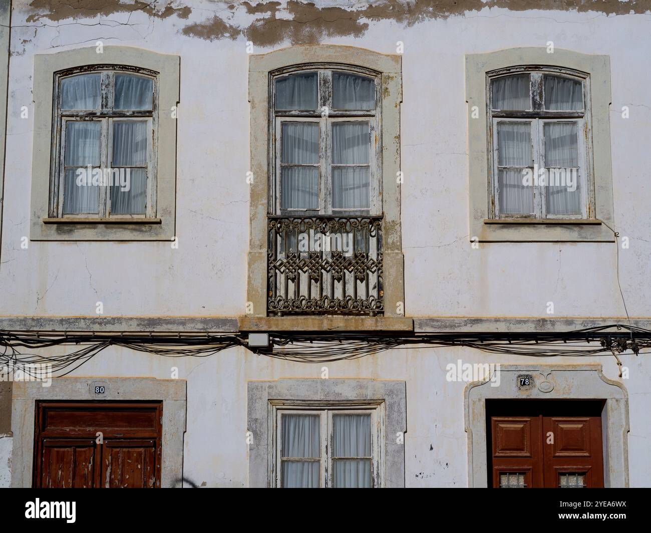 Facciata di un edificio residenziale con balconi decorativi e fili elettrici che attraversano Lagos, Portogallo. Lagos è una città nel sud del ... Foto Stock