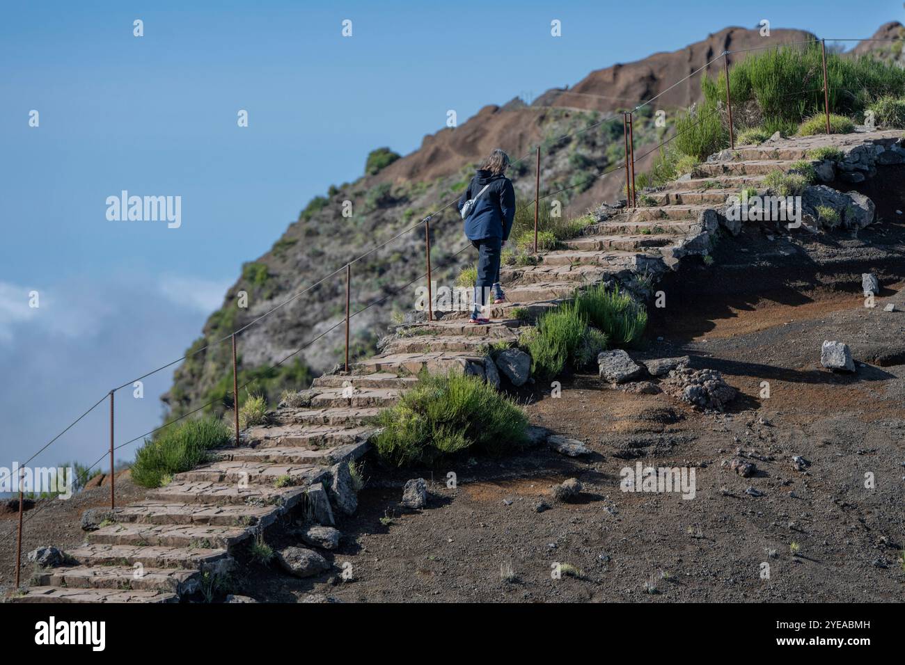 Il turista femminile sale i gradini della destinazione escursionistica ad alta quota di Pico do Areeiro, sull'isola di Madeira, Portogallo Foto Stock