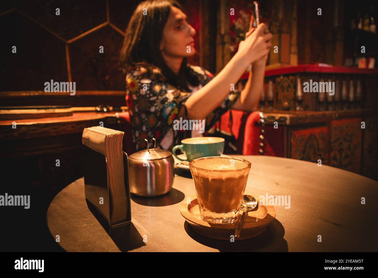 Yerevan, Armenia - 19 ottobre 2024: Donna turistica gusta bere caffè fresco cappuccino scatta una foto per blogging Lumen Coffee 1936 Cafe. Famou speciale Foto Stock
