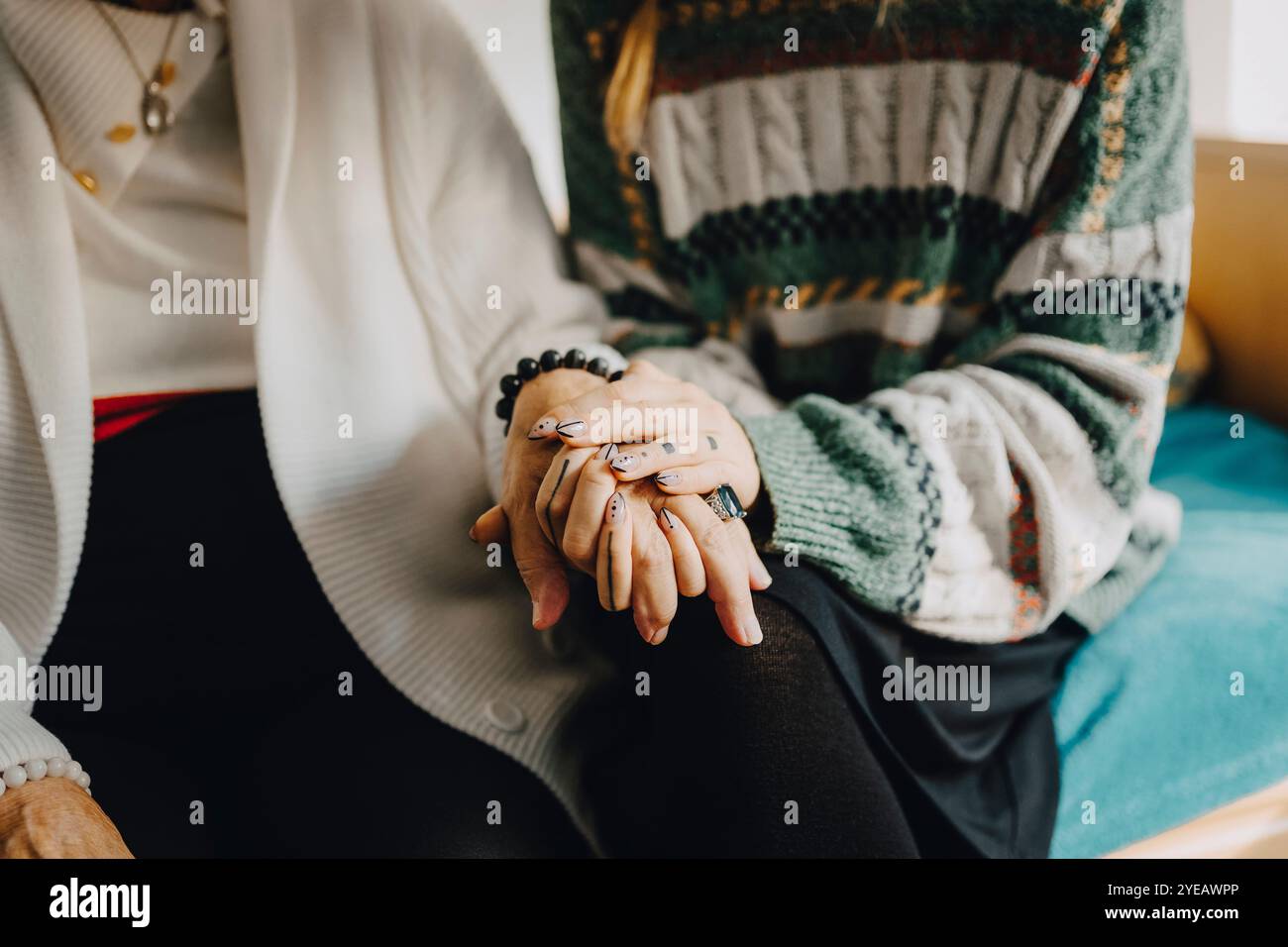 Sezione centrale dell'infermiera che consola la donna anziana nella casa di riposo Foto Stock