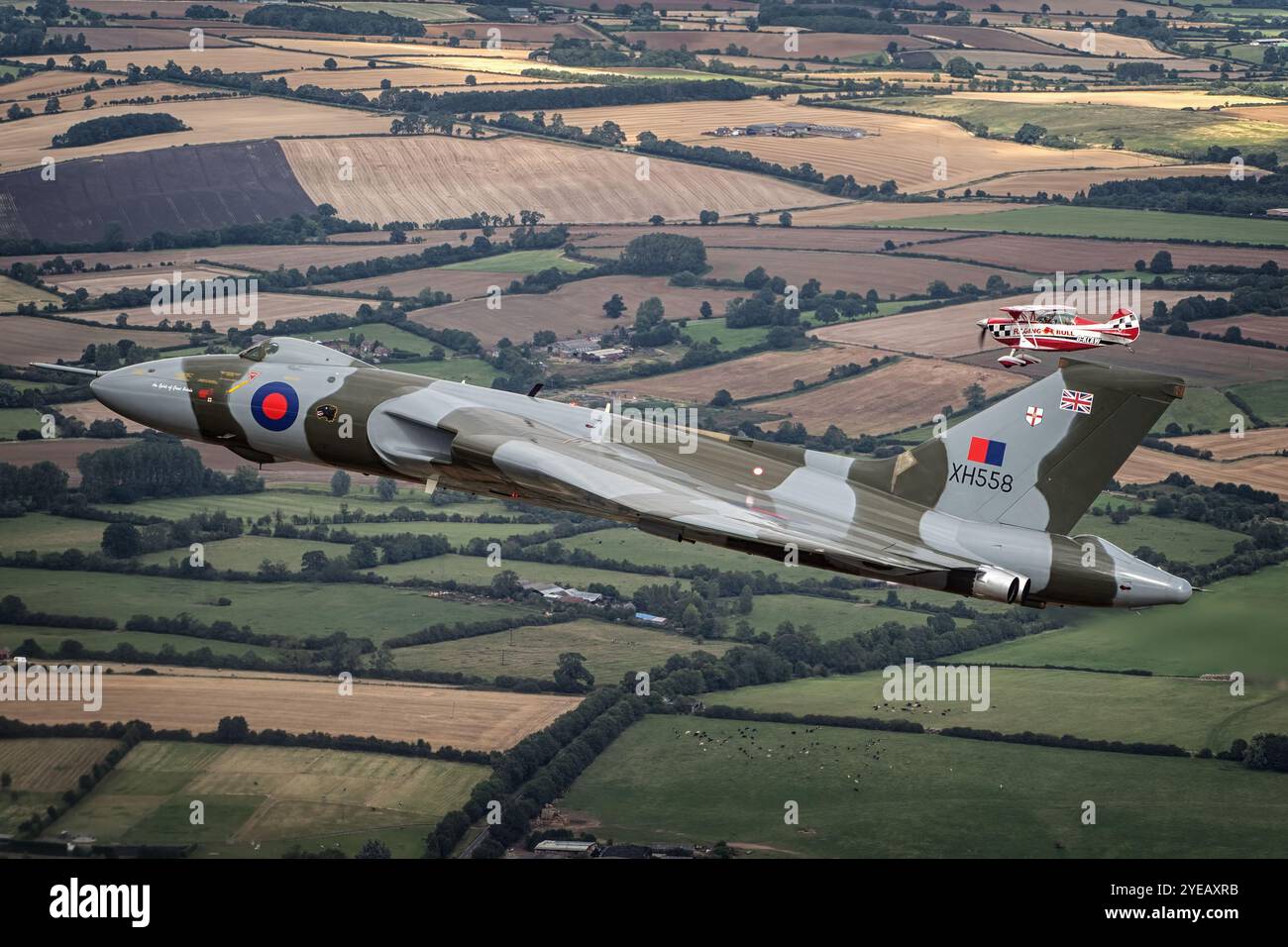 Formazione di bombardieri vulcanici Avro volando con una Christen Eagle II sopra il Northamptonshire. Foto Stock