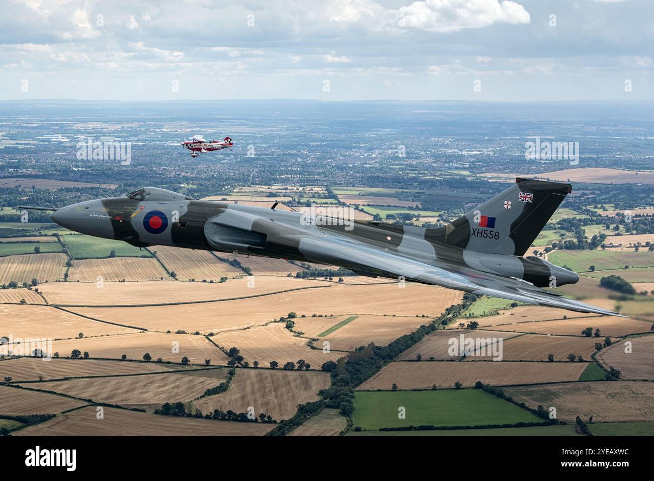 Formazione di bombardieri vulcanici Avro volando con una Christen Eagle II sopra il Northamptonshire. Foto Stock