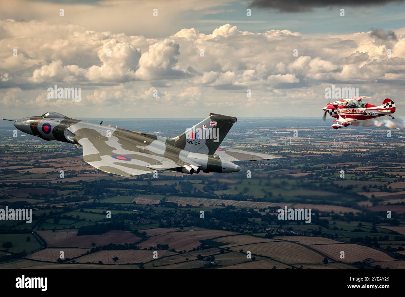 Formazione di bombardieri vulcanici Avro volando con una Christen Eagle II sopra il Northamptonshire. Foto Stock