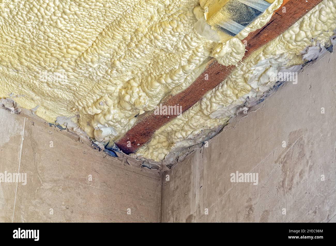 Coperture in espanso per soffitto per isolamento. Lavori di costruzione interni. Travi in legno, pareti in cemento. Riparazione Foto Stock