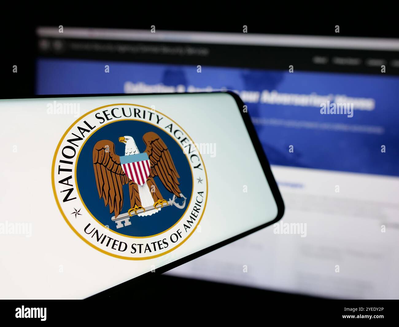 Smartphone con logo dell'Agenzia nazionale per la sicurezza (NSA) sullo schermo davanti al sito Web. Mettere a fuoco la parte centrale sinistra del display del telefono. Foto Stock