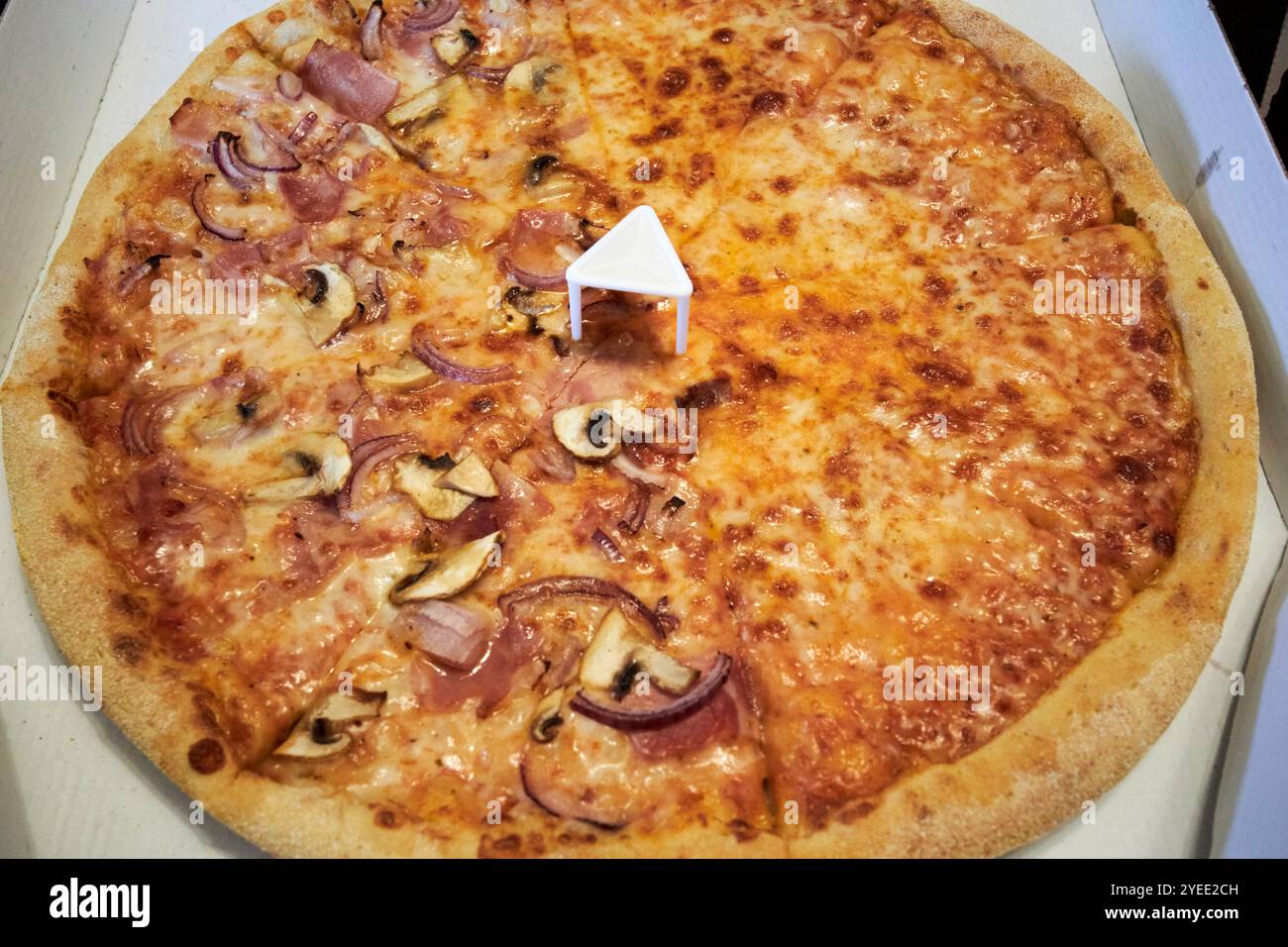 la pizza apache spaccata mezza e mezza pizza con metà formaggio ha prosciutto e funghi con treppiede per pizza , contea di mayo, repubblica d'irlanda Foto Stock