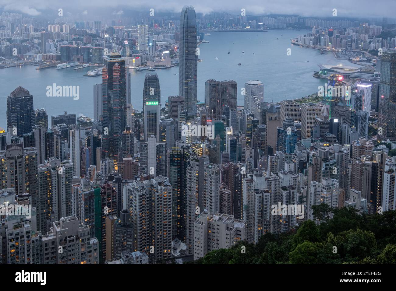 Dal picco al crepuscolo, lo splendido panorama del Victoria Harbour prende vita, con Central e Kowloon illuminati contro un cielo sereno. Foto Stock