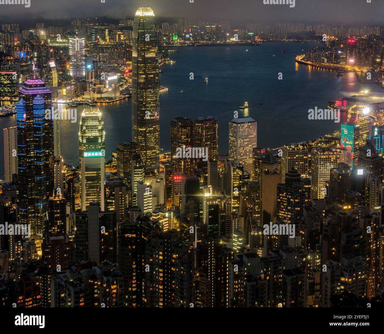 All'imbrunire dal picco, si dispiega lo splendido panorama del Victoria Harbour, con lo skyline di Central e Kowloon illuminati contro una serata limpida. Foto Stock