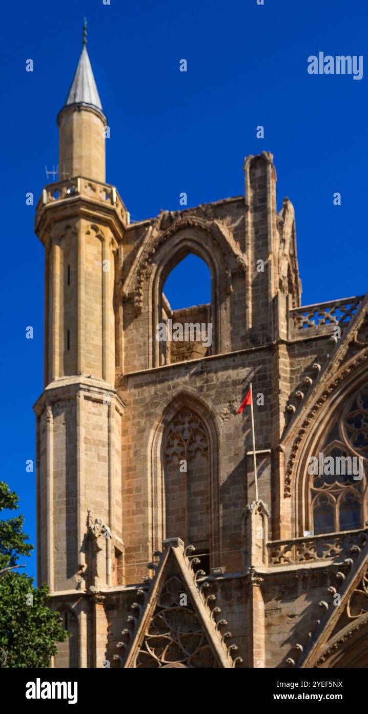 Il sole mette in risalto le intricate opere in pietra della torre della chiesa, rivelando la sua ricca storia in vividi dettagli. Foto Stock