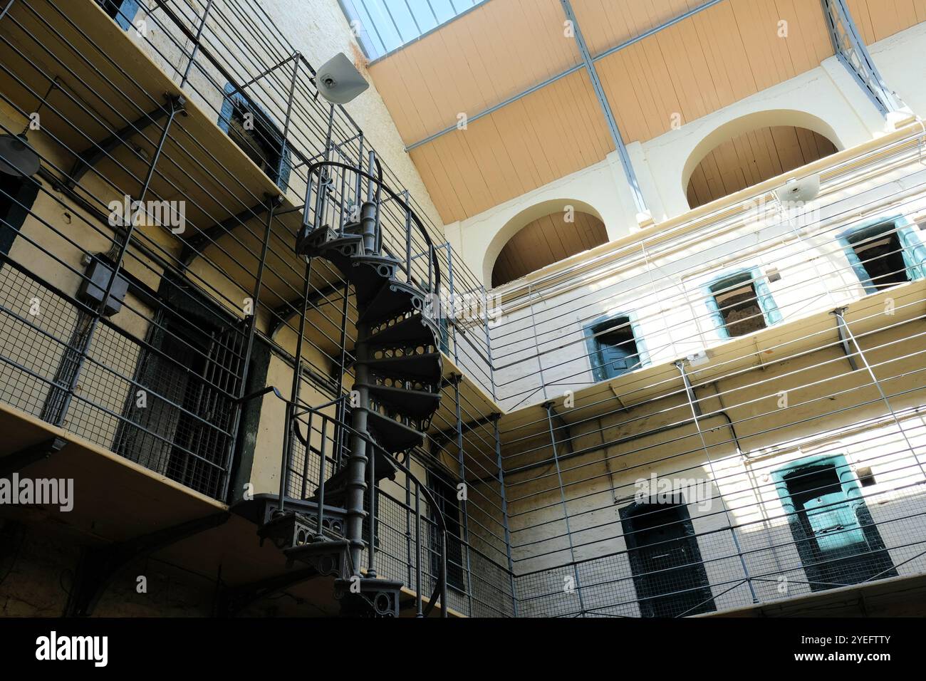 Scala metallica a spirale e piani superiori visti dalla sala principale della prigione Kilmainham Gaol, Dublino, Irlanda; ex prigione ora monumento nazionale. Foto Stock