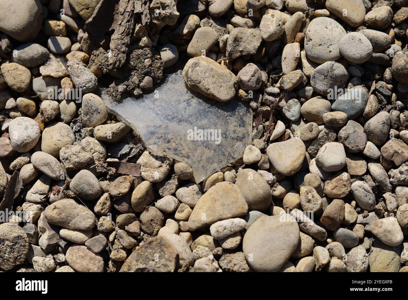 Frammenti di vetro rotti adagiati su rocce Foto Stock