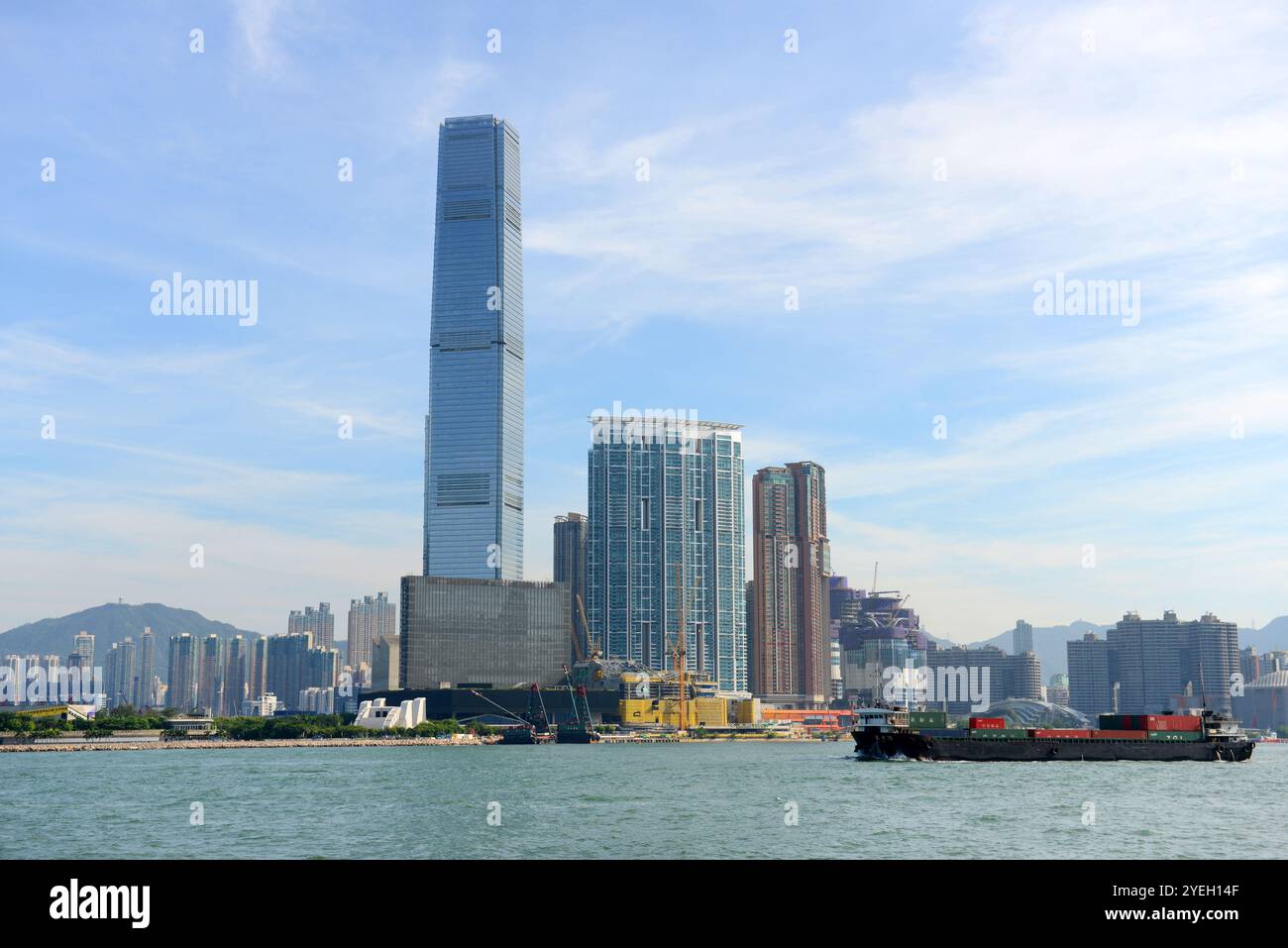 Una piccola nave portacontainer che attraversa il Victoria Harbour di Hong Kong. Foto Stock