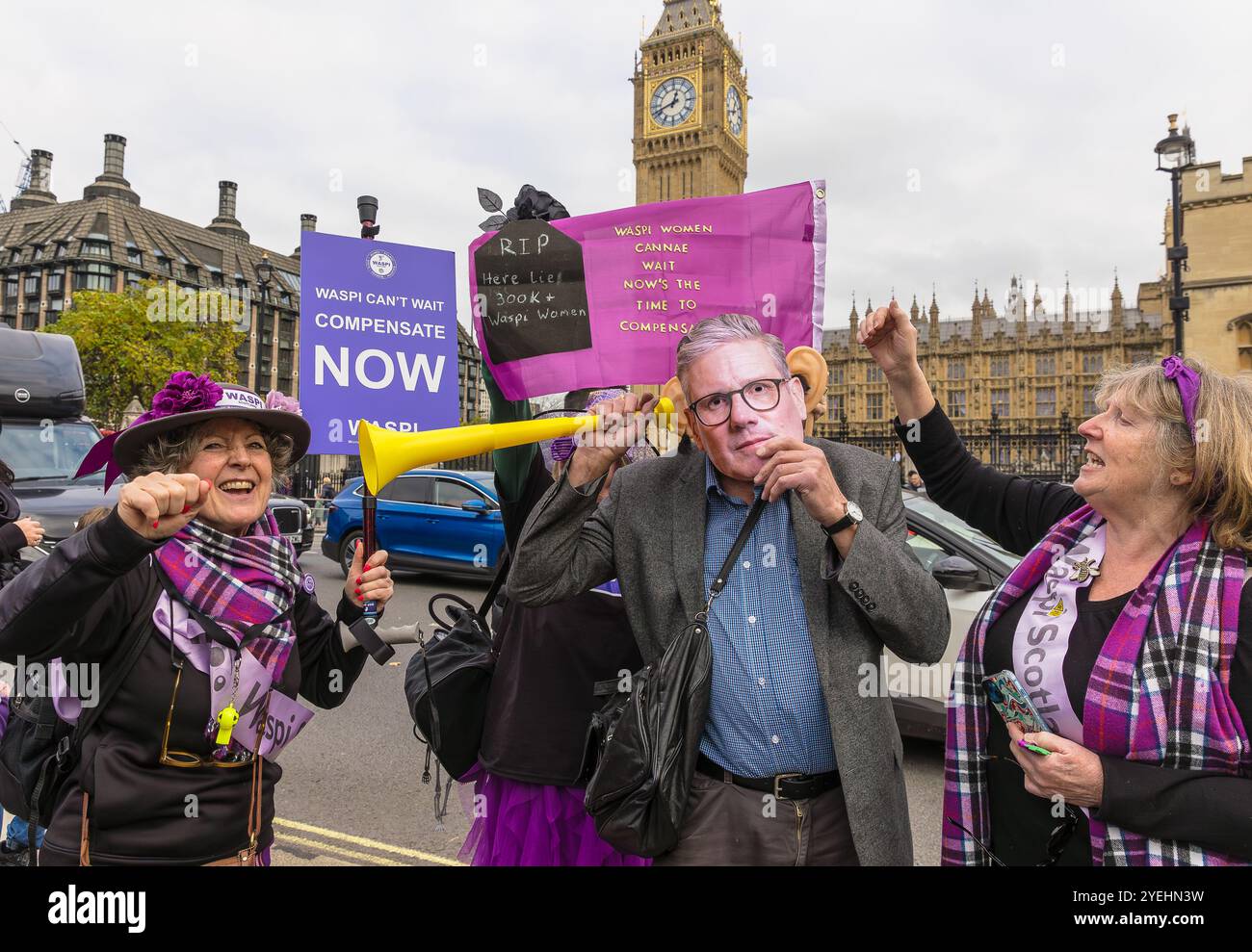 Westminster, Londra, Regno Unito, ottobre 30 2024, dimostrazione WASPI in occasione del budget Day, con un uomo che indossa una divertente maschera Keir Starmer e due donne WASPI W Foto Stock