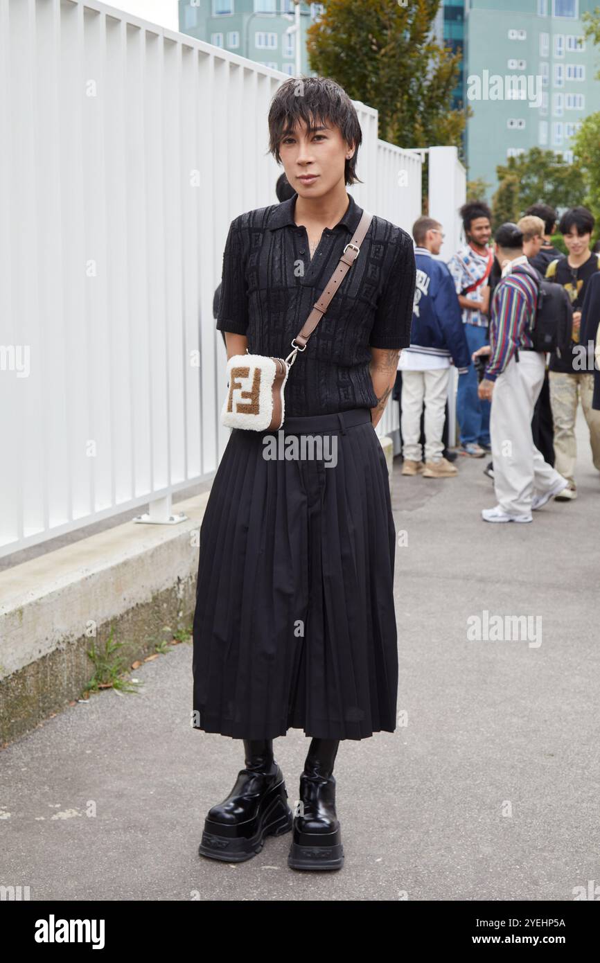 MILANO, ITALIA - 17 SETTEMBRE 2024: Uomo con camicia Fendi nera e gonna a pieghe prima della sfilata Fendi, Street style di Milano Foto Stock