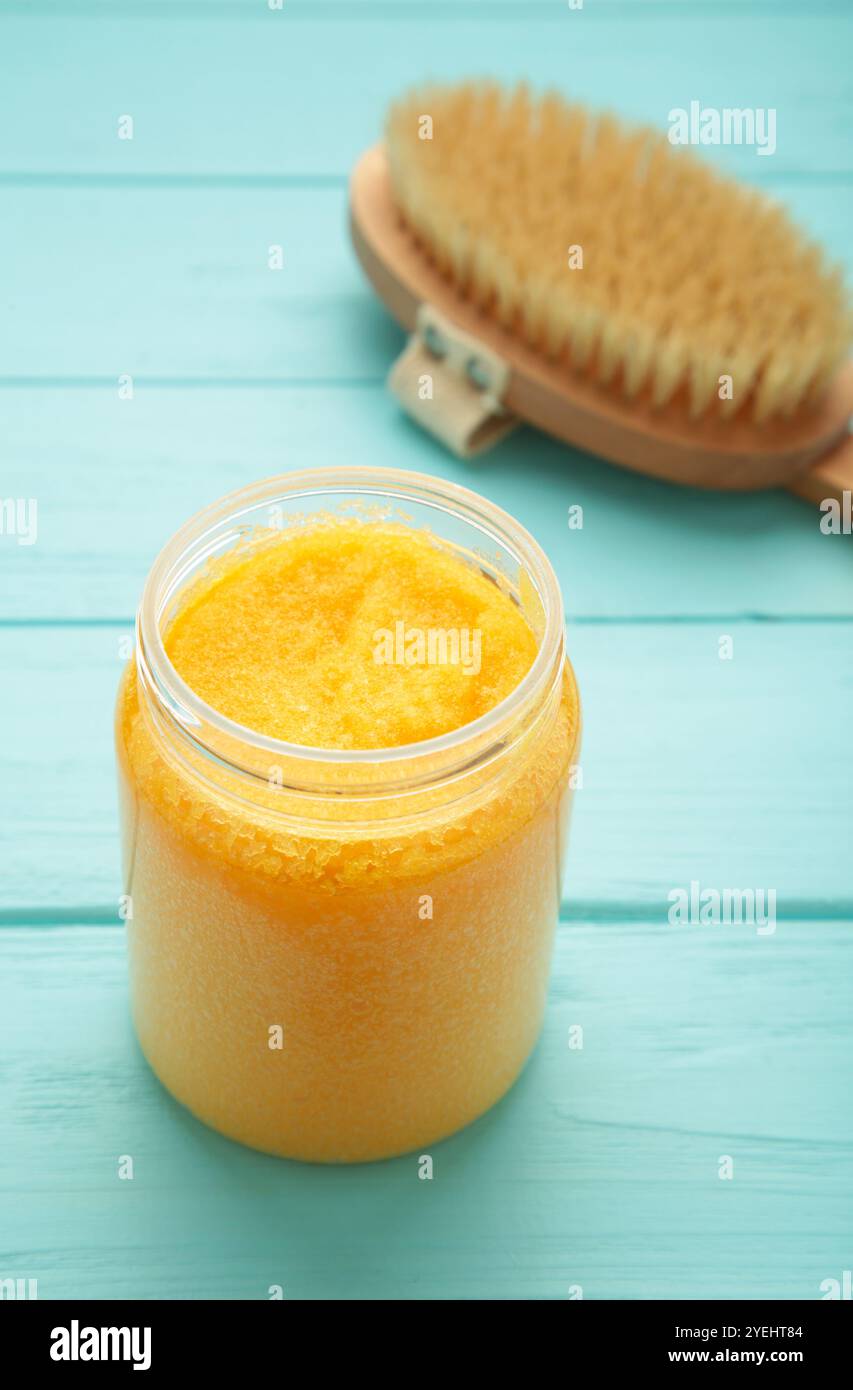 Pasta di zucchero fatta a mano con olio di Argan. Strofinare con la spazzola massaggiante su sfondo blu. Vista dall'alto Foto Stock