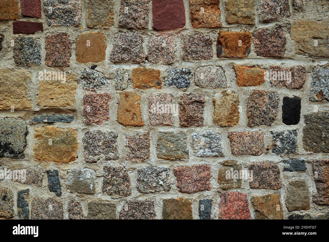 Vecchio edificio esterno con pareti in pietra sullo sfondo. Mattoni colorati invecchiati naturalmente, nessuna gente Foto Stock