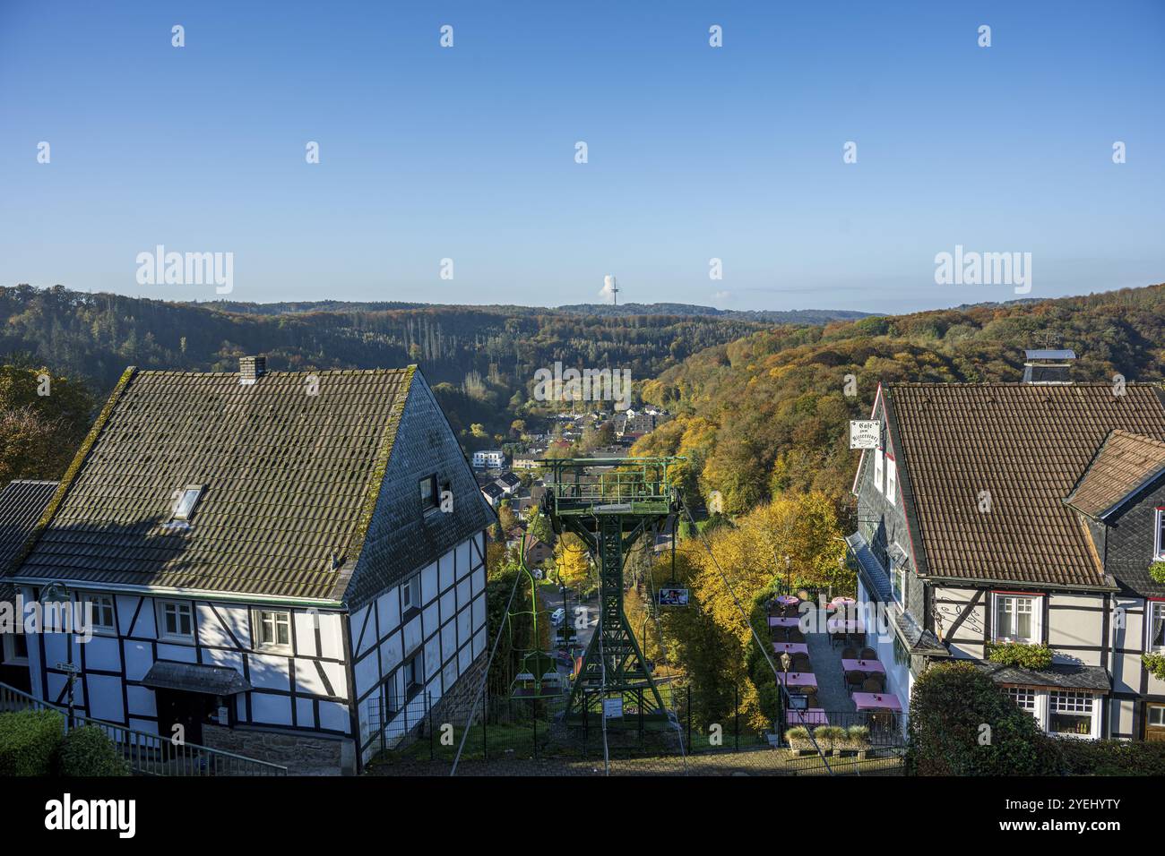 Ammira un villaggio con case a graticcio e una foresta colorata autunnale sullo sfondo, il castello di Burg nella regione della Bergisches Land Foto Stock