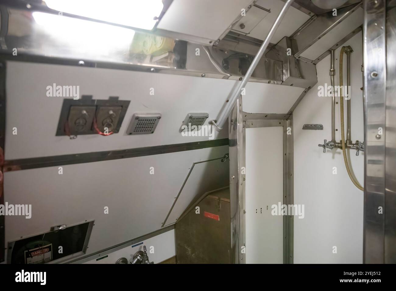 Questa immagine mostra una sezione di un sottomarino che somiglia a un piccolo bagno o area doccia. Foto Stock