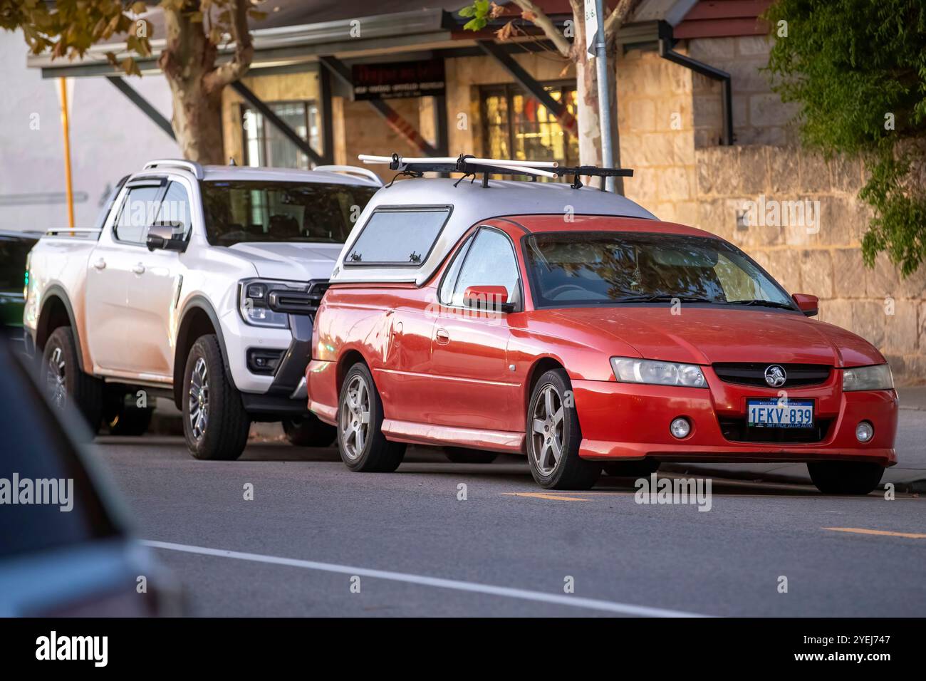 Una Holden ute rossa parcheggiata in una strada suburbana, caratterizzata da un baldacchino argentato e portapacchi. Foto Stock