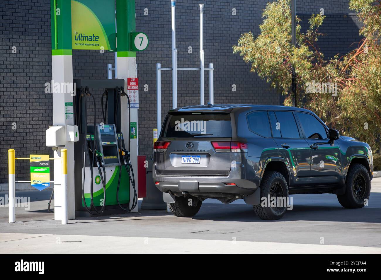 Una Toyota Land Cruiser grigia parcheggiata in una stazione di rifornimento BP, che mostra un SUV moderno alla pompa in condizioni di sole. Foto Stock
