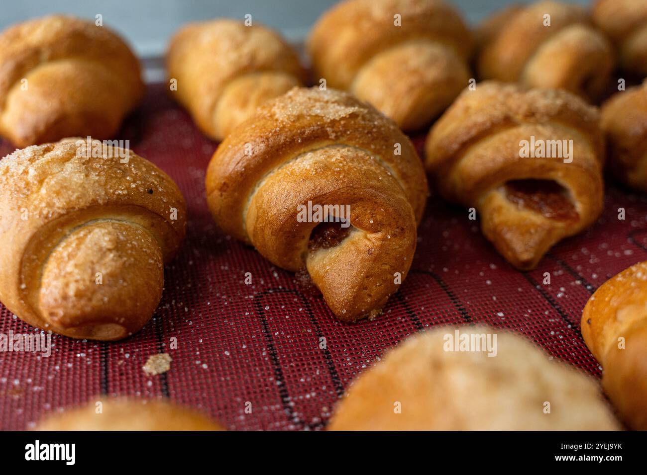 Croissant o bagel con marmellata sul piano di produzione. Mini panetteria, pasticcini squisiti. Foto di alta qualità Foto Stock