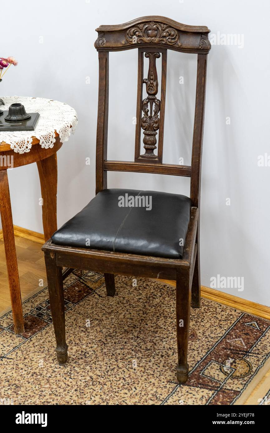 Vecchia sedia in legno con intagli in legno. Mobili. Sedile in pelle Foto Stock