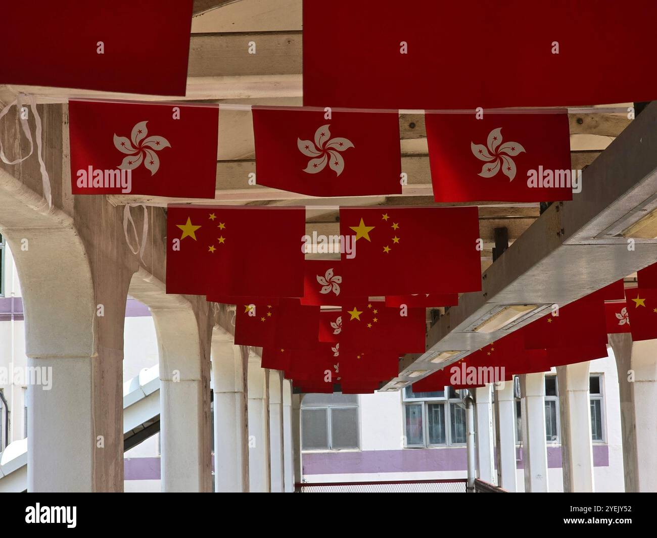 Bandiere cinesi e di Hong Kong che decorano un ponte pedonale per la giornata nazionale della Cina. Quarry Bay, Hong Kong. Foto Stock