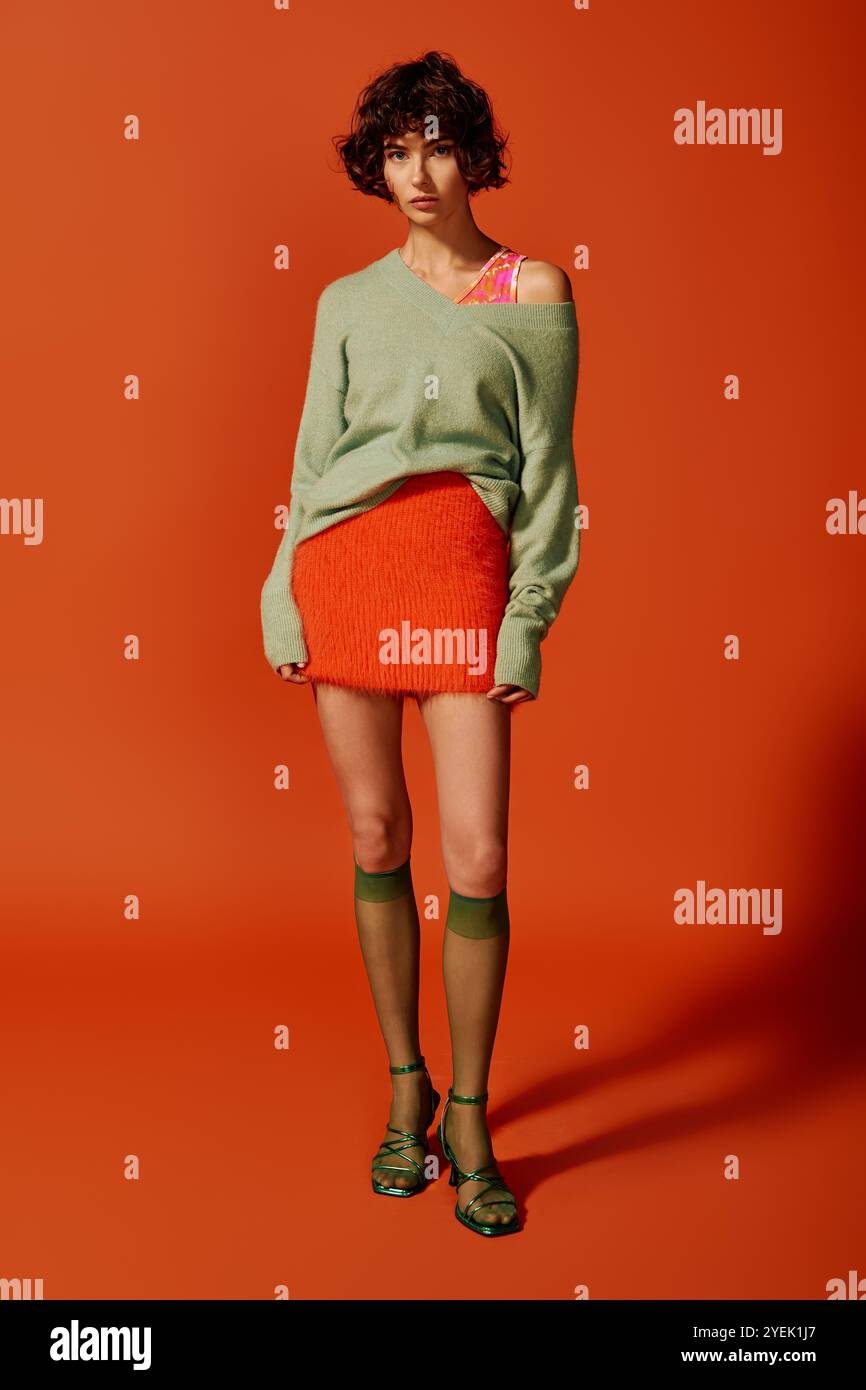 Una giovane donna mostra la sua individualità attraverso un abbigliamento colorato e un'espressione sentita. Foto Stock