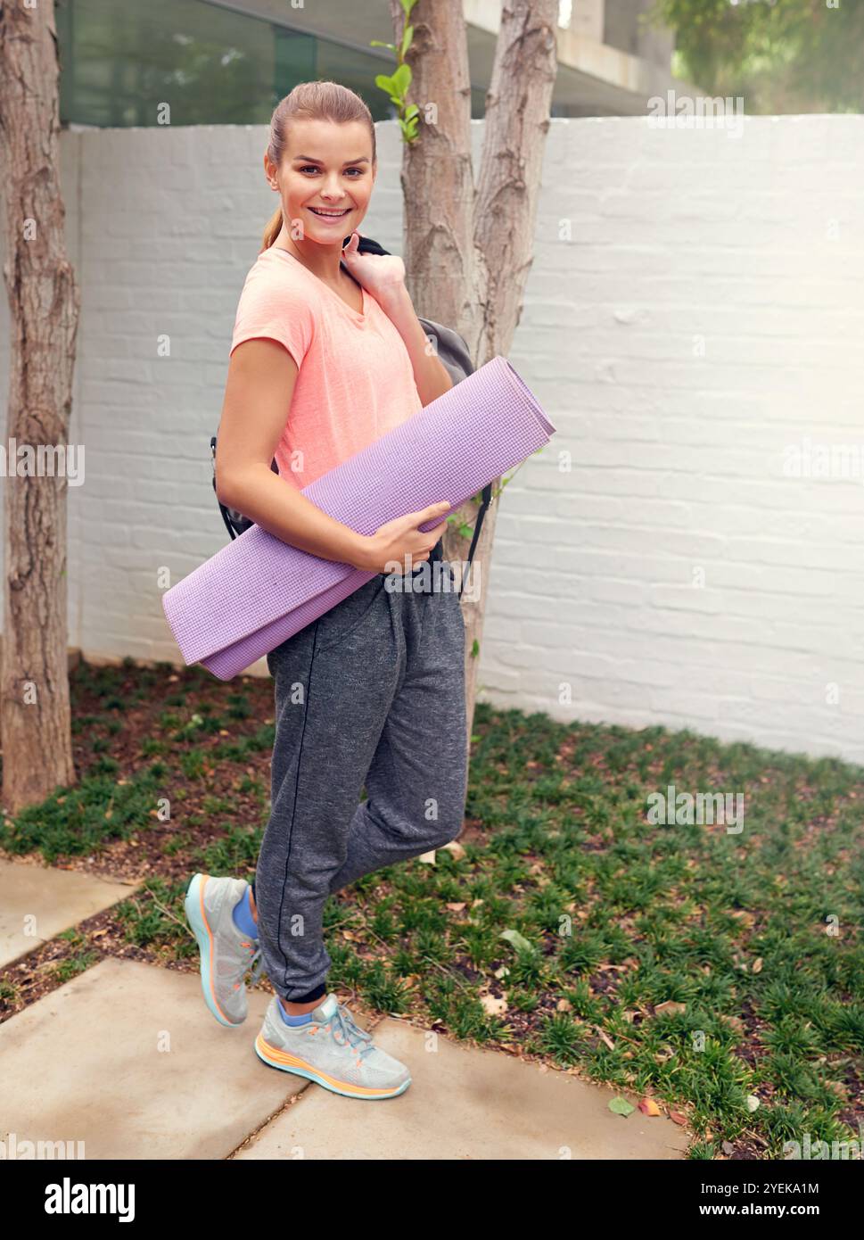 Ritratti, camminate e yoga con una donna all'aperto, partenza per iniziare l'esercizio fisico o la routine di fitness. Olistica, pilates e sorriso di yogi in giardino Foto Stock