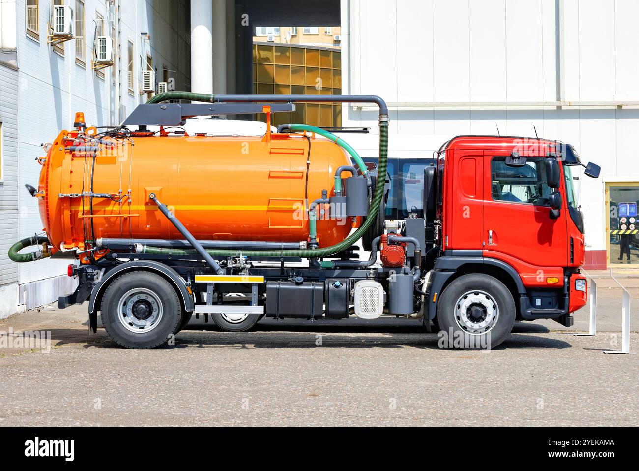 Carrello per liquami professionale parcheggiato vicino a un edificio industriale, che fornisce servizi essenziali di gestione dei rifiuti. Foto Stock