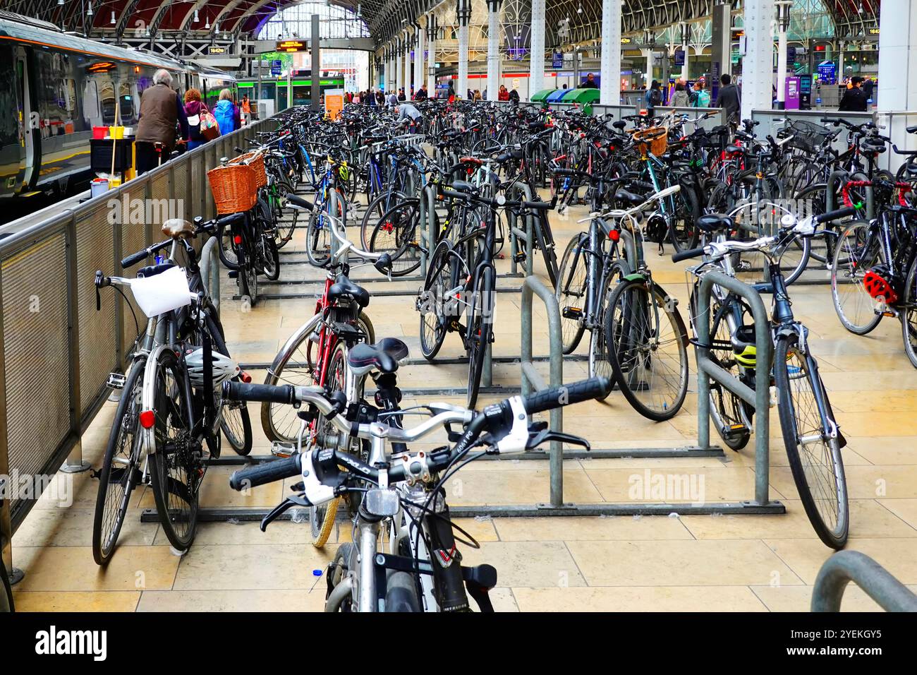 L'atrio della stazione di Paddington ospita un enorme parco per biciclette pendolari in un'area separata accanto alla piattaforma ferroviaria, biciclette con lucchetto su telai in acciaio Londra, Inghilterra, Regno Unito Foto Stock