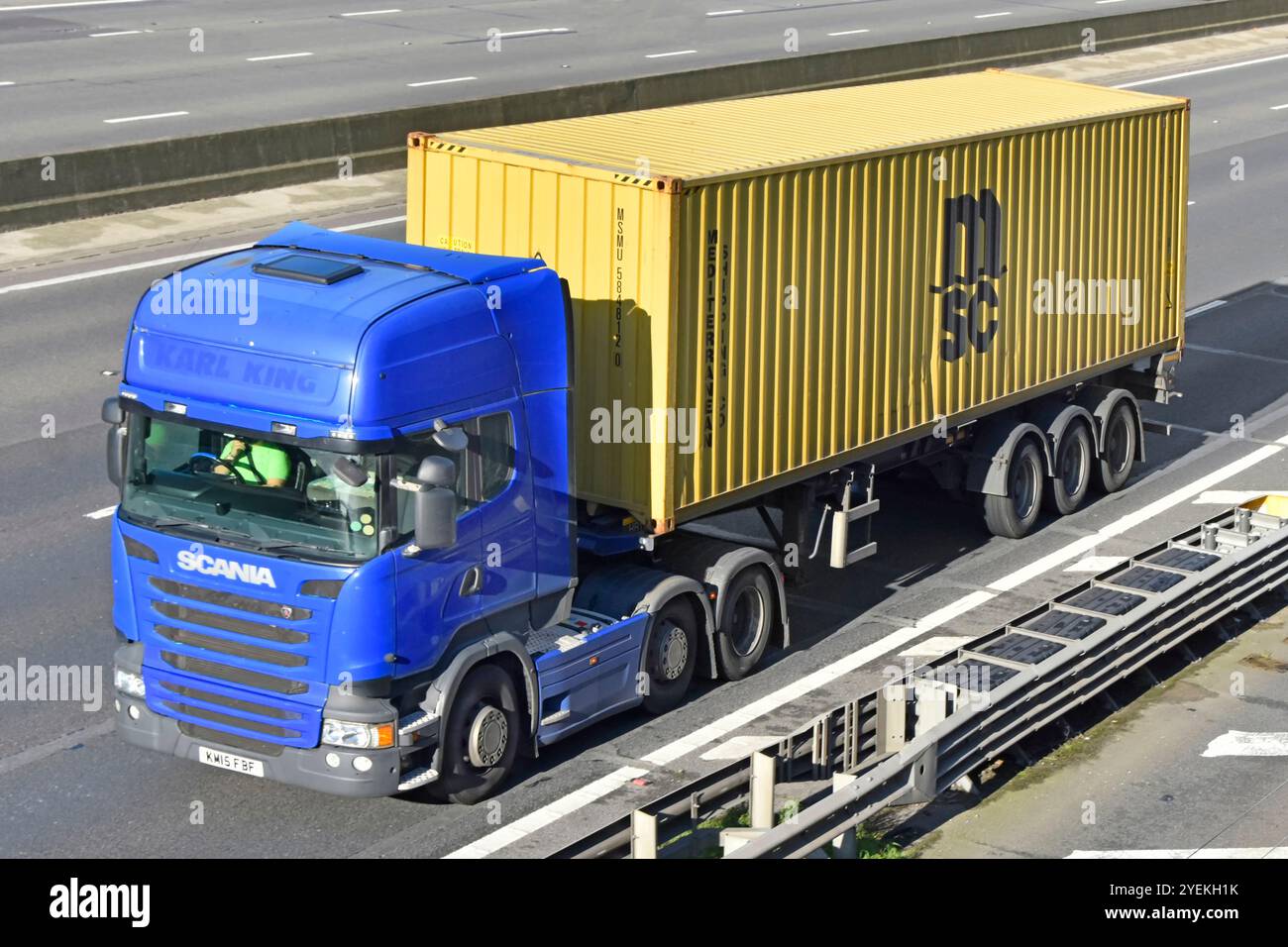 Contenitore di spedizione MSC su rimorchio articolato con scheletro trainato dal conducente blu del marchio Scania al lavoro autocarro hgv M25 strada autostradale Essex Inghilterra Regno Unito Foto Stock