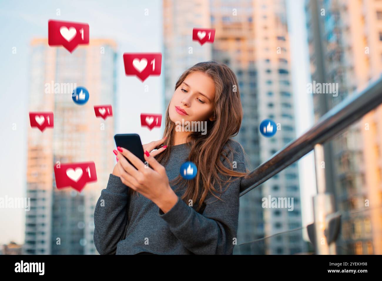 La giovane donna urbana riceve i mi piace sui social media, utilizzando l'app di incontri online sugli smartphone sullo sfondo della città Foto Stock