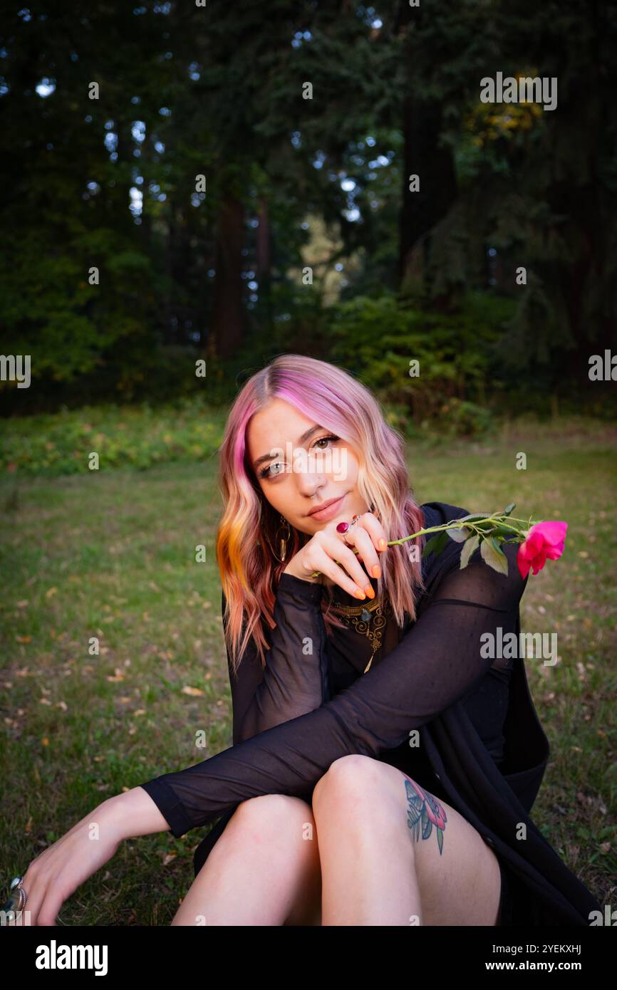 Ragazza con i capelli colorati posa con una rosa al Mt. Tabor Park a Portland, OREGON. Foto Stock