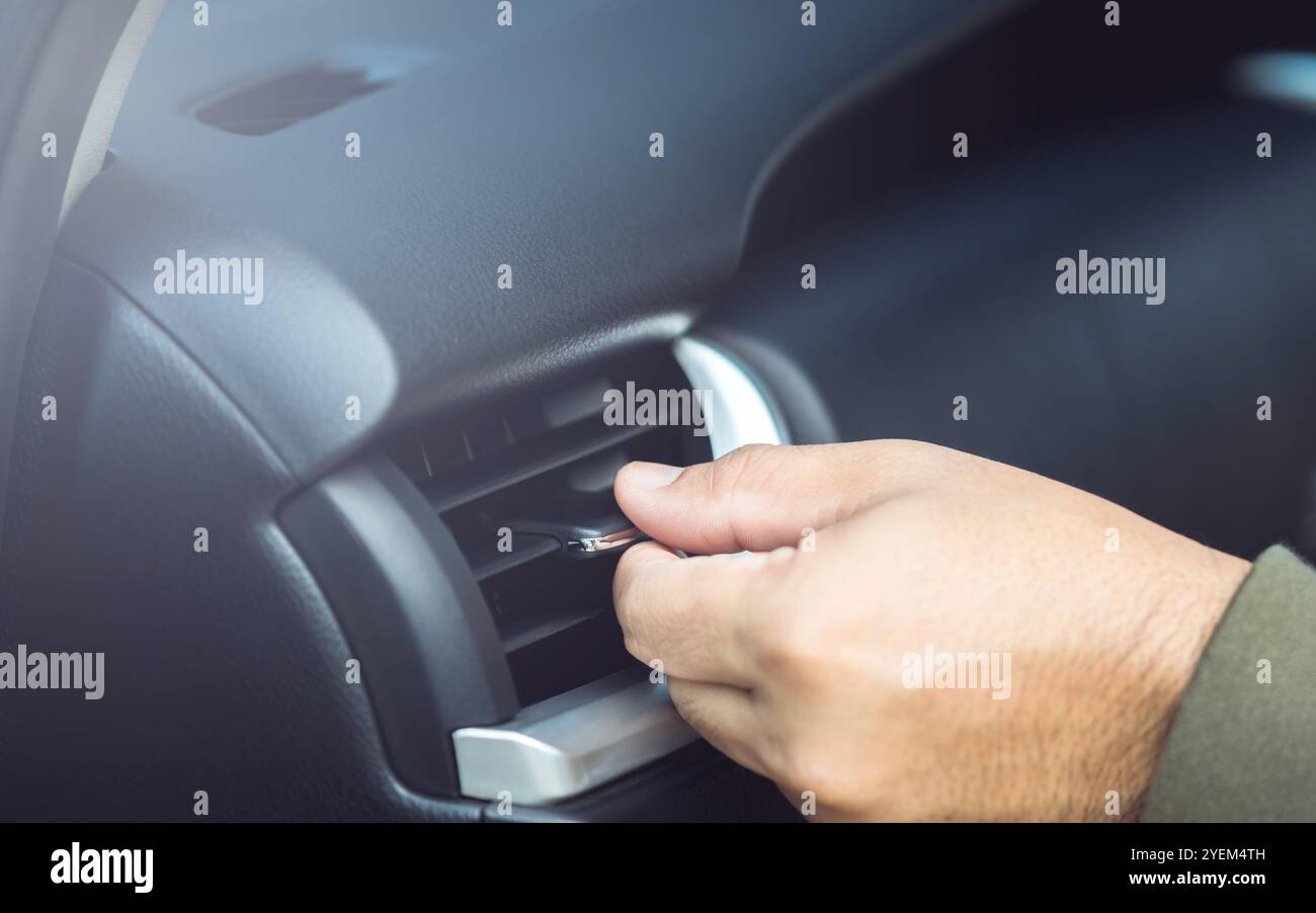 Il proprietario di un'auto regola manualmente la direzione della presa d'aria, garantendo un flusso d'aria ottimale all'interno del veicolo. Manutenzione corretta del veicolo e aria condizionata corretta Foto Stock