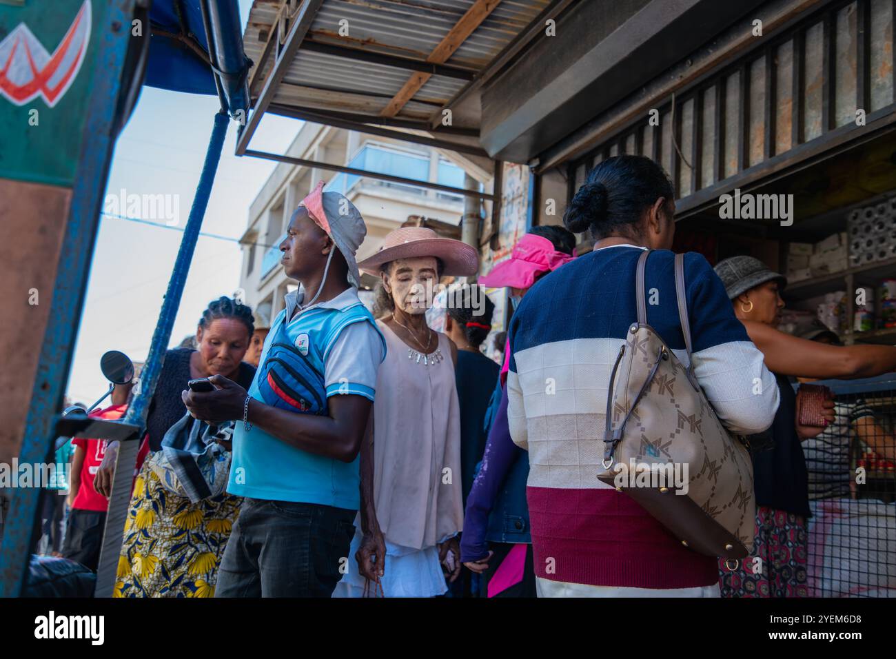 Morondava, Madagascar - 26 agosto 2024: Donne con maschere solari bianche tradizionali a base di radici di alberi e polvere di corteccia vengono viste impegnate quotidianamente Foto Stock