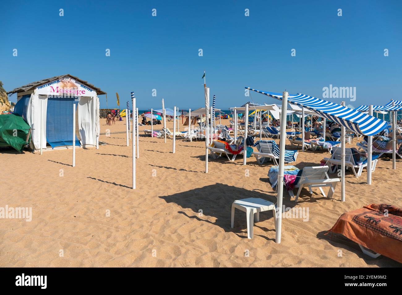 Portogallo, regione dell'Algarve, Albufeira, Praia dos Pescadores (Spiaggia dei pescatori) con tenda da massaggio e tonalità di righe di sole Foto Stock