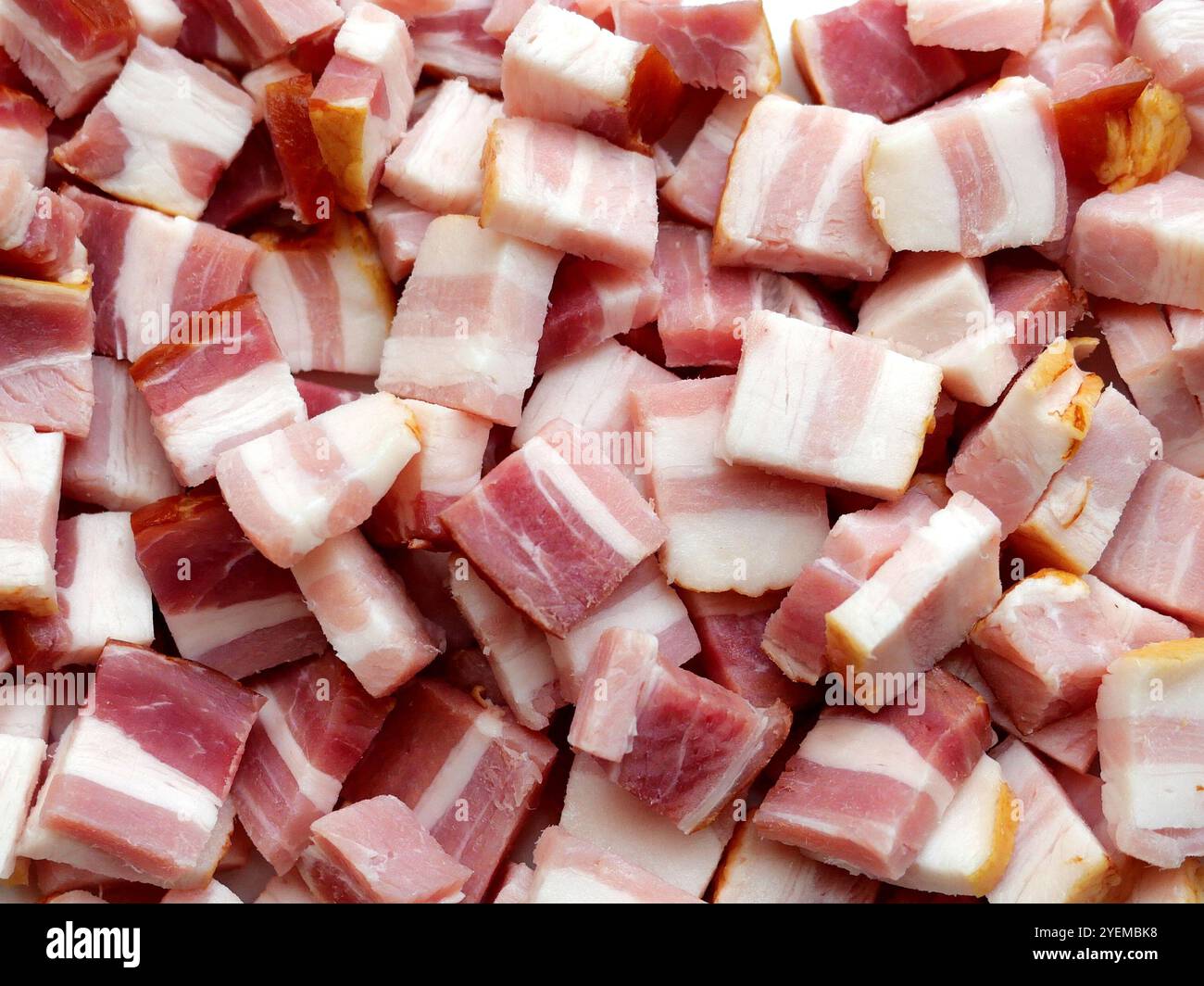 Primo piano di cubetti di pancetta di maiale bianca e rossa, tagliati a dadini per il gulasch. L'immagine dettagliata è un invito a cucinare ed è ideale per libri di cucina o blog di cibo. Foto Stock