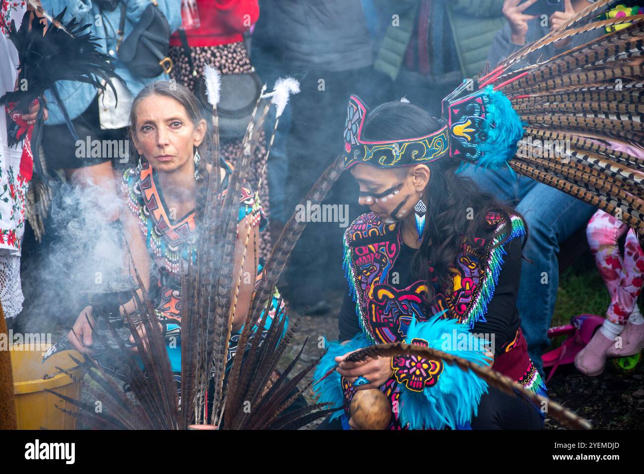 Un membro del gruppo di danza detiene un detentore di incenso mentre l'altro suona musica durante lo spettacolo. I ballerini aztechi di Atlachinolli hanno partecipato al Day of the Dead 2024 (dia de Muertos) a Camden Town, Londra. Day of the Dead è l'evento messicano più antico in cui i messicani ricordano i loro cari con cibo, bevande e decorazioni. Foto Stock