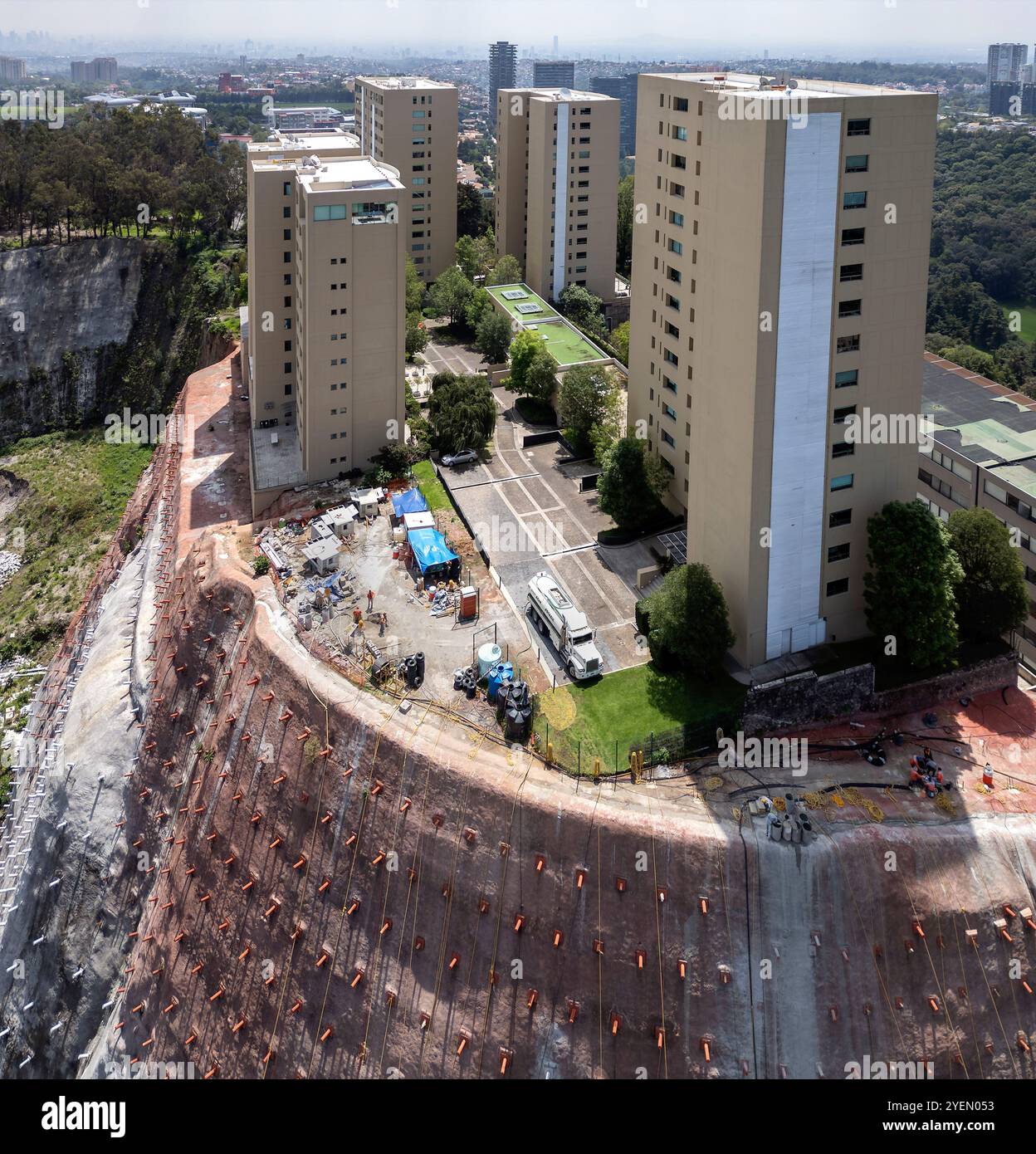 Lavori di rinforzo della scogliera su un tumulo con edifici alti Foto Stock
