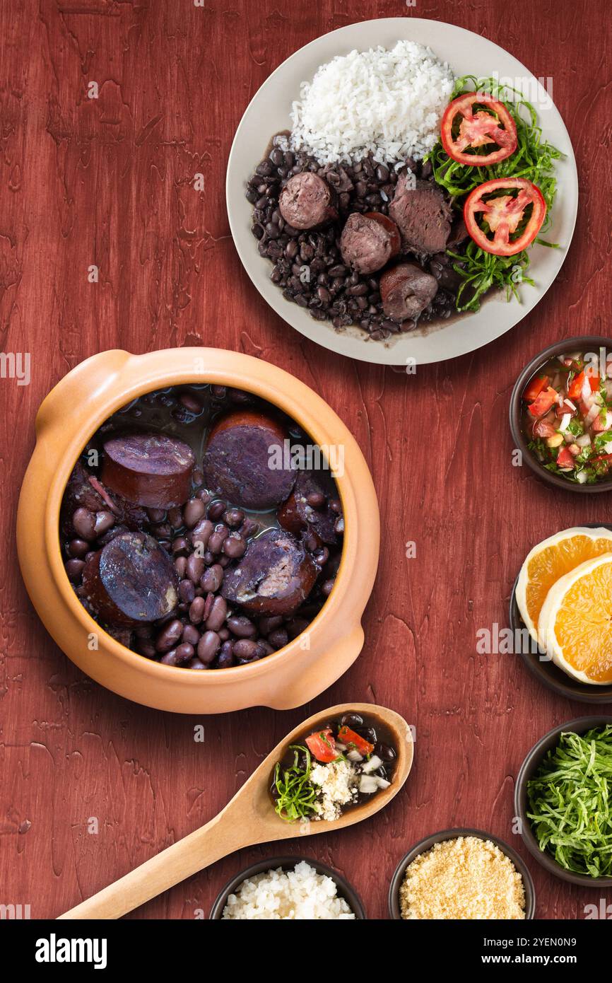 Tradizionale feijoada brasiliana con sfondo rosso. Foto Stock