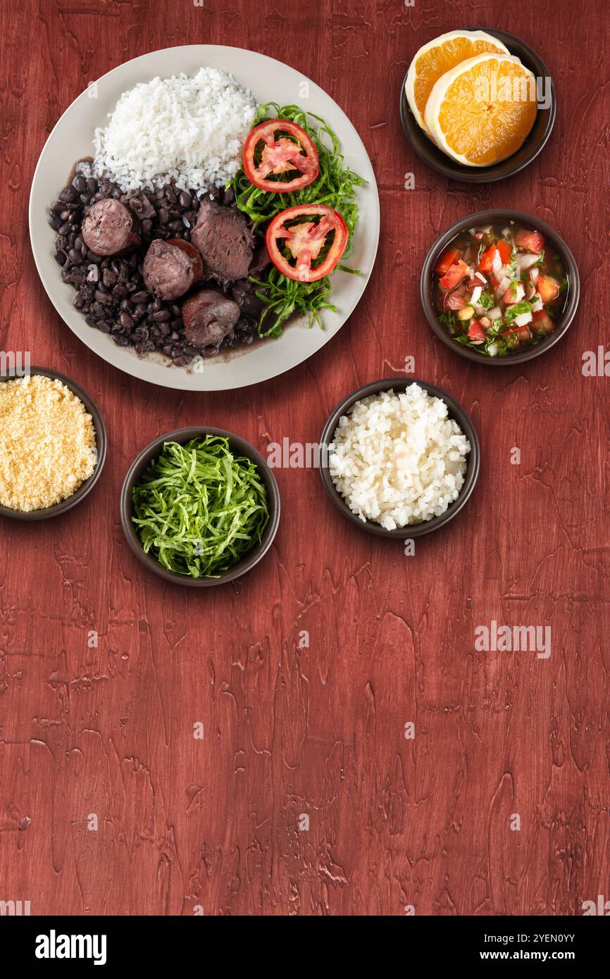 Tradizionale feijoada brasiliana con sfondo rosso. Foto Stock